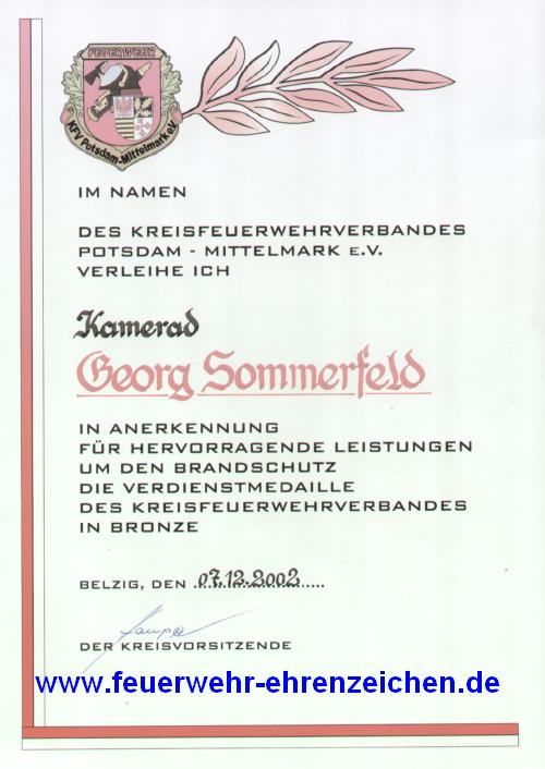 IM NAMEN DES KREISFEUERWEHRVERBANDES POTSDAM-MITTELMARK E.V. VERLEIHE ICH Kamerad Georg Sommerfeld IN ANERKENNUNG FÜR HERVORRAGENDE LEISTUNGEN UM DEN BRANDSCHUTZ DIE VERDIENSTMEDAILLE DES KREISFEUERWEHRVERBANDES IN BRONZE